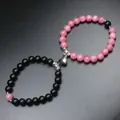 Close-up of magnetic couple beaded bracelets with heart-shaped clasp detail - Rhodochrosite