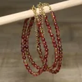 Close-up of handmade round bead necklace with gold extension chain and lobster clasp. - Bright Red