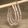Close-up detail of handmade white turquoise beaded necklaces with gold lobster clasp - Apricot Red