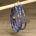 Macro detail of blue lapis lazuli beaded necklace with gold stainless steel chain - Blue & White