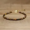 Detailed macro view of faceted brown natural stone beads on a dainty gold bracelet - Brown & Yellow