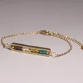 Detailed view of a gold plated bar bracelet featuring colorful natural gemstone beads. - Mixed Amethyst and Quartz