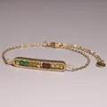 Detailed macro view of a gold-plated bar bracelet set with natural gemstone beads - Green and Brown Ores