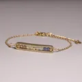 Macro view of a gold-plated bracelet with multicolored natural stone beads in a cage pendant. - Blue and Tea Gradient Stone