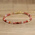 Close-up of handmade faceted natural stone beaded bracelet with adjustable gold clasp - Coral Pink
