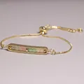 Detailed view of a gold-plated adjustable bracelet with beaded rectangular bar pendant. - Pink White and Green Beads