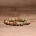 Detailed view of 8mm natural Indian agate beaded bracelet on wooden background - Unakite