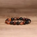 Detailed close-up view of 8mm natural Indian Agate beaded bracelet on wooden surface - Red Striped Agate