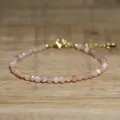 Close-up of faceted natural stone beaded bracelet with golden adjustable clasp on wood. - Light Yellow