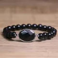 Détail rapproché d'un bracelet de perles noires avec pierre centrale ovale facettée - Obsidienne