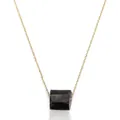 Primer plano de un collar minimalista con un colgante de piedra natural negra irregular - Turmalina