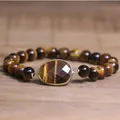 Vue détaillée d'un pendentif en pierre d'œil de tigre facettée sur bracelet perlé - Œil de tigre