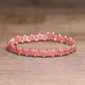 Handgemaakte roze gestreepte kralen elastische armband met decoratieve gouden accenten - Roze