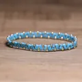 Handgemaakte elastische armband met blauwe steen en gouden kralen in zigzagpatroon - Zwarte Lijn Turkoois