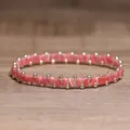 Handmade pink striped beaded elastic bracelet with decorative gold spherical beads - Rhodonite