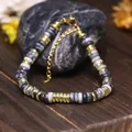Bracciale regolabile con perle in pietra naturale grigia e accenti dorati in acciaio. - Pietra a Rete Nera