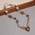 Vue détaillée d'un collier en perles de verre vintage avec un pendentif cœur ambre - Style glaçure en forme de cœur ambre (XL0105)