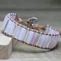 Detailed close-up of natural rose quartz cylinders and silver spacers on leather cord - Rose Quartz
