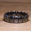 Gedetailleerd overzicht van gepolijste zwarte hematietkralen op een elastische armband - Afgeronde Rechthoek Stijl (#1)