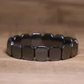 Detail shot of a minimalist black hematite stone stretch bracelet on wooden surface - Wide Rectangle Style (#8)