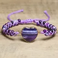 Nahaufnahme des lila Amethyst-Perlenarmbands mit Herzanhänger auf Holzuntergrund. - Lila Streifen