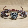 Nahaufnahme eines handgeflochtenen Armbands mit herzförmigem Schneeflocken-Obsidian-Stein. - Schwarz Weiß