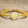 Nahaufnahme eines gelben Herz-Naturstein-Armbands auf einem rustikalen Holzuntergrund - Zitronengelb