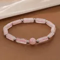 Close-up of pink crystal energy bracelet with rectangular beads and silver accents - Rose Quartz