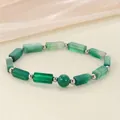 Close-up of green stone bead bracelet with silver spacers on soft textured background - Green Agate