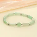 Detailed view of a natural green stone beaded bracelet with silver spacers. - Aventurine