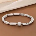 Close-up of a stylish white marble texture stone bead bracelet with silver separator accents - Howlite