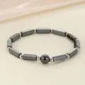 Close-up macro view of a black hematite magnetic energy bead bracelet for women - Hematite