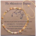 Bracelet en pierre de Picasso tissé à la main avec accents dorés sur carte de remise de diplôme - L'aventure Commence 02 (Pierre Ton Terre Corde Jaune)