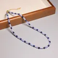 Élégant collier de perles vintage lavande et bleu marine exposé sur un plateau en bois - Style Rétro Perles Cylindriques Bleues et Violettes (XL0130)