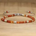 Handmade adjustable natural red stone beaded bracelet with silver spacers on wood. - Grey Cord Red Agate Style / Brick Red