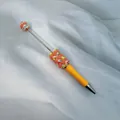 Custom handmade beaded pen with yellow barrel and colorful peach heart candy beads - Orange