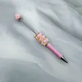 DIY pink macaron beaded pen with heart charms on soft white silk fabric background - Khaki Pink