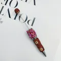 Luxurious handmade beaded ballpoint pen featuring red rhinestones and 3D pink rose motifs. - Lava Gold