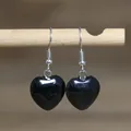 Close-up of elegant black natural stone heart drop earrings hanging from a wooden stick - Heart Style 9 (Black Obsidian)