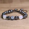 Detailopname van hematiet kralenarmband met Om-symbool en gefacetteerde kralen - Opaal