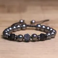 Detailopname van hematiet kralenarmband met Om-symbool en gefacetteerde accenten - Zwarte agaat
