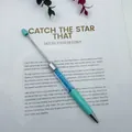 Teal DIY beadable ballpoint pen filled with blue crystal gravel on magazine paper - Candy Light Blue