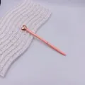 Elegant pink ballpoint pen with a rose gold heart topper on white display stand - Rice Pink