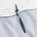 Macro view of a 0.5mm retractable black gel pen with transparent barrel and green grip - 10 Pieces/Pack (0.5mm) / Black