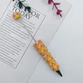 Gelber dekorativer Kugelschreiber mit orangefarbenen Schleifen und Perlen als Geschenk - Orange