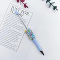 Close-up of DIY beaded ballpoint pen featuring colorful candy sprinkle decorations - 1.0mm Bullet Tip / Aqua Blue