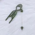 Olive green U-shaped hair fork styling tool with dangling beads on fur background - Lotus Green