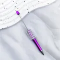 Elegant purple beaded ballpoint pen featuring decorative pearls and rhinestone accents. - 1.0mm Bullet Tip / UV Purple