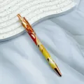 Elegant retractable metal ballpoint pen featuring red and yellow marble pattern with rose gold trim - 1.0mm Bullet Tip / Bronzing Yellow