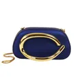 Close-up detail of a navy blue evening clutch with a bold gold C-shaped metal ornament - Blue
